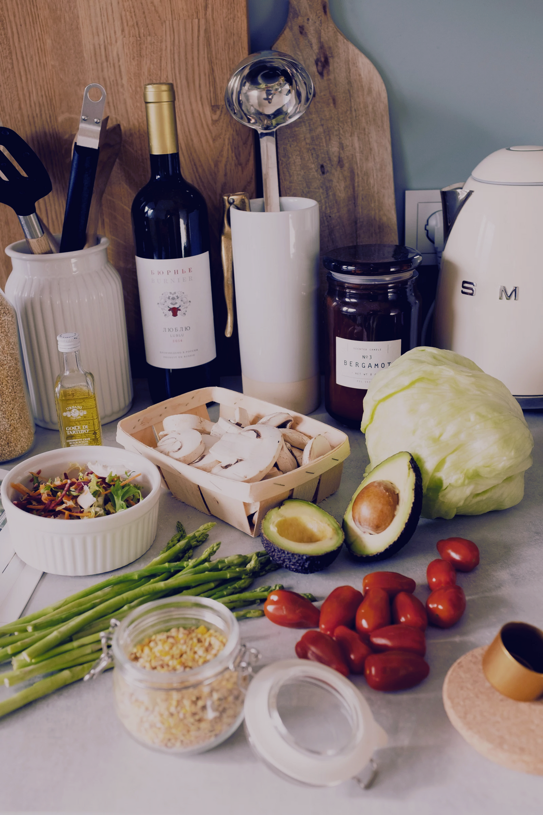 sliced avocado, cabbage, mushrooms, oil, beans, and other ingredients laid out on a surface