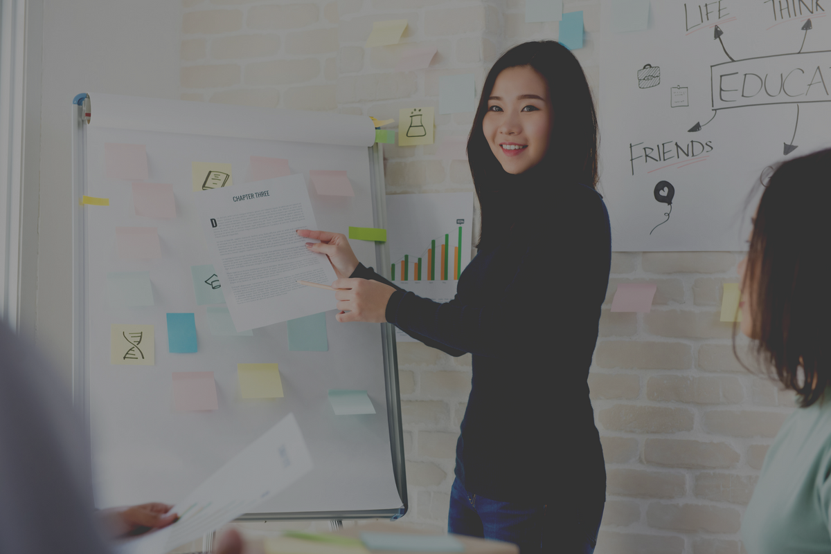 Asian woman standing next to a board